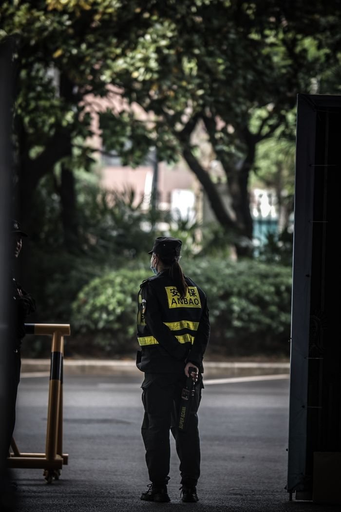 Security guard in uniform stands vigilantly outdoors in Shanghai, China.