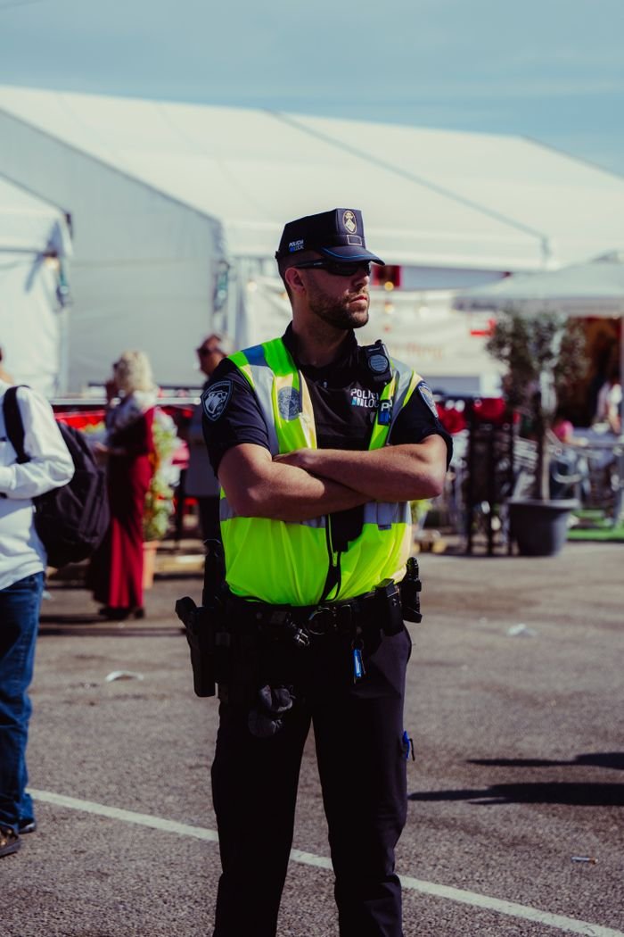 Police officer in high-visibility vest managing outdoor event security.