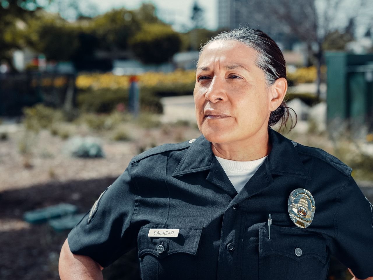 Portrait of a female police officer standing confidently outdoors in uniform.